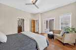 Step into this inviting bedroom featuring a comfortable bed with a dark grey textured comforter and a light grey throw.