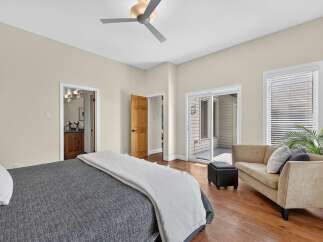 Step into this inviting bedroom featuring a comfortable bed with a dark grey textured comforter and a light grey throw.