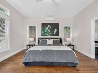 Experience ultimate comfort in this beautifully appointed bedroom, featuring a plush king-size bed adorned with luxurious grey and white linens.