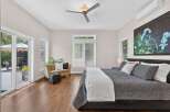 Experience luxurious living in this spacious master bedroom, featuring a king-sized bed adorned with plush pillows and a cozy throw.