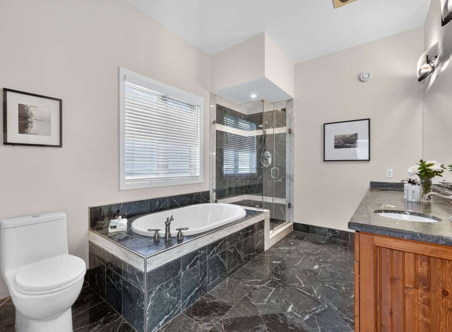 Indulge in luxury in this stunning bathroom featuring a deep soaking tub and a separate glass-enclosed shower.