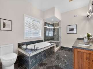 Indulge in luxury in this stunning bathroom featuring a deep soaking tub and a separate glass-enclosed shower.