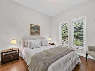 Experience tranquility in this inviting bedroom, featuring a plush bed adorned with decorative pillows and a cozy throw blanket.