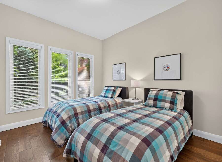 This charming bedroom features two twin beds with stylish plaid bedding, perfect for accommodating guests or children.