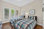 This charming bedroom features two twin beds with stylish plaid bedding, perfect for accommodating guests or children.