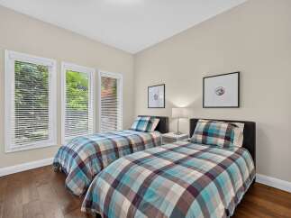 This charming bedroom features two twin beds with stylish plaid bedding, perfect for accommodating guests or children.