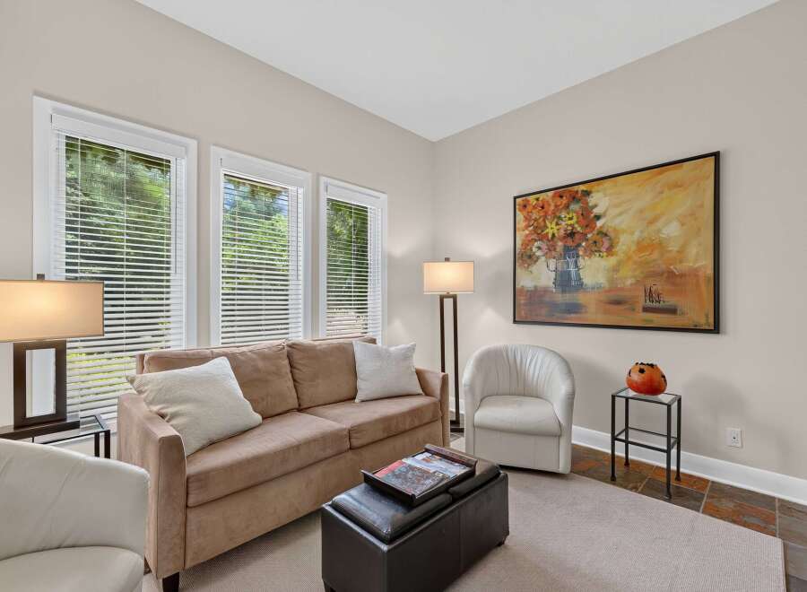 This inviting living room features a plush tan sofa adorned with white throw pillows, perfect for relaxation.