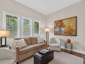 This inviting living room features a plush tan sofa adorned with white throw pillows, perfect for relaxation.