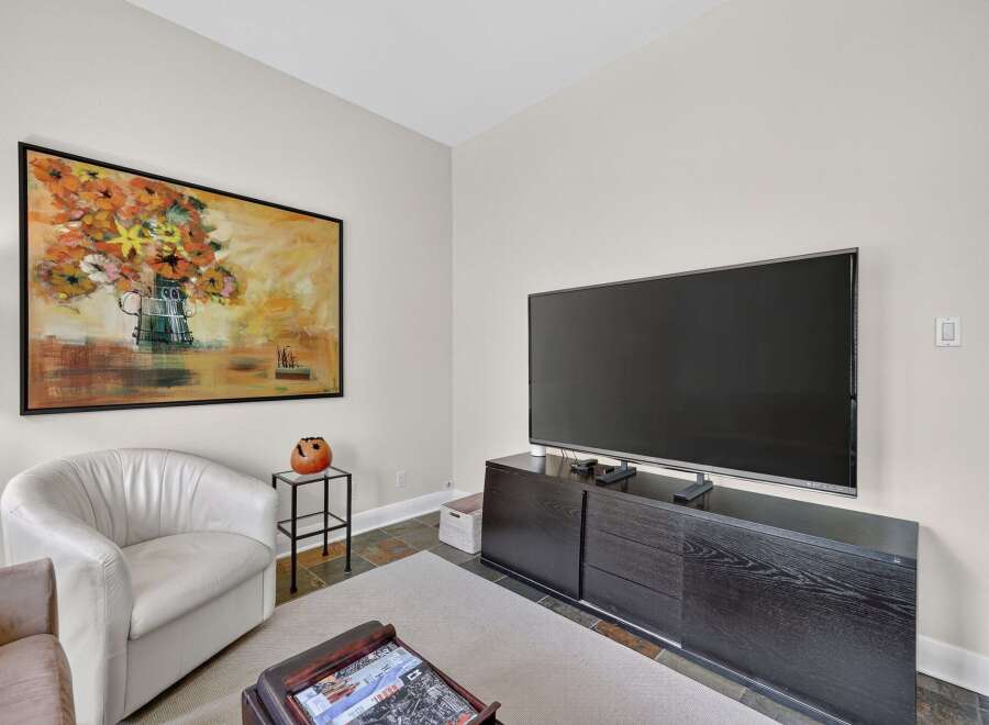 This living room features a large flat-screen TV mounted above a sleek, dark wood media console, perfect for entertainment.