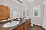 This spacious bathroom features a double vanity with ample counter space and storage, perfect for any household.