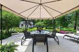 Enjoy outdoor living under this elegant gazebo, featuring a glass-top dining table and four chairs perfect for al fresco meals.