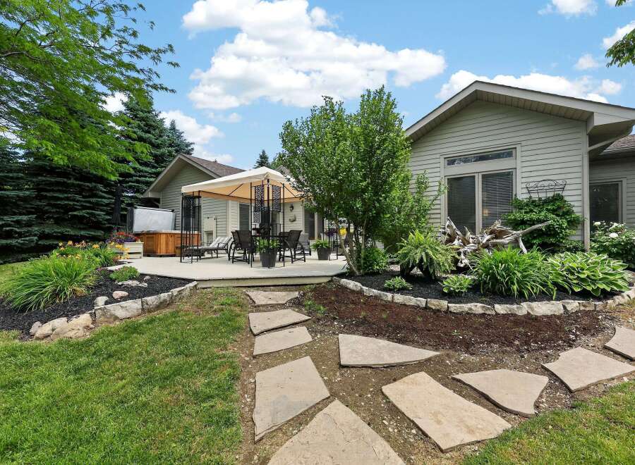 Enjoy outdoor living with this spacious deck featuring a covered seating area and a hot tub, perfect for relaxation and entertaining.