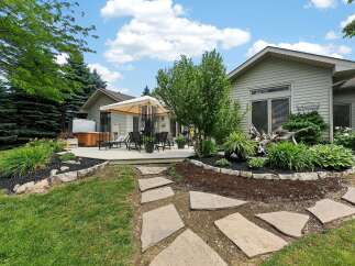 Enjoy outdoor living with this spacious deck featuring a covered seating area and a hot tub, perfect for relaxation and entertaining.