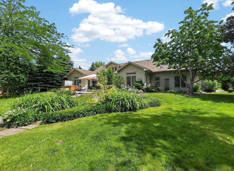 Enjoy outdoor living in this stunning backyard featuring a luxurious hot tub and a spacious patio area perfect for entertaining.