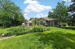 Enjoy outdoor living in this stunning backyard featuring a luxurious hot tub and a spacious patio area perfect for entertaining.