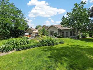Enjoy outdoor living in this stunning backyard featuring a luxurious hot tub and a spacious patio area perfect for entertaining.