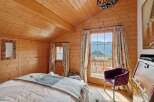 Experience rustic charm and breathtaking mountain views from this cozy bedroom.