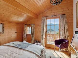 Experience rustic charm and breathtaking mountain views from this cozy bedroom.