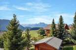 Experience serene mountain living in this charming wooden chalet, nestled amidst lush greenery and offering breathtaking views of snow-capped peaks.
