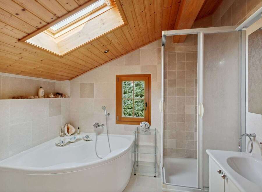 Experience ultimate relaxation in this charming bathroom featuring a luxurious corner bathtub and a separate glass-enclosed shower.