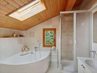 Experience ultimate relaxation in this charming bathroom featuring a luxurious corner bathtub and a separate glass-enclosed shower.