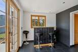 Step into this inviting space featuring a rustic wooden bar with sleek black paneling, perfect for entertaining.