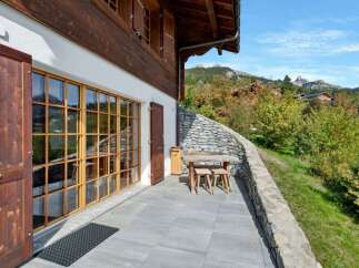 Enjoy breathtaking mountain views from this charming chalet's spacious patio, perfect for al fresco dining or relaxing with a book.