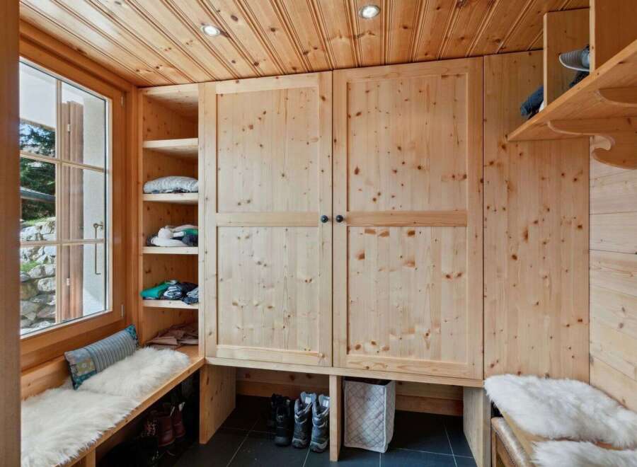 This charming entryway features a built-in wooden wardrobe and shelving, perfect for organizing outerwear and accessories.