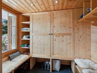 This charming entryway features a built-in wooden wardrobe and shelving, perfect for organizing outerwear and accessories.