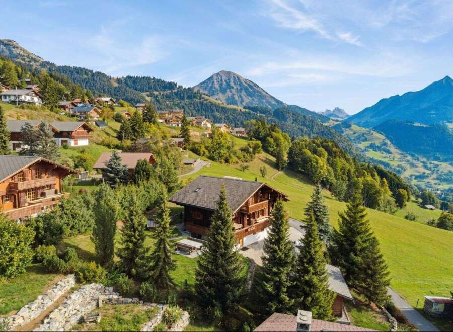 Experience the charm of alpine living in this stunning property nestled amidst rolling green hills and majestic mountains.