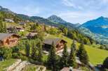 Experience the charm of alpine living in this stunning property nestled amidst rolling green hills and majestic mountains.