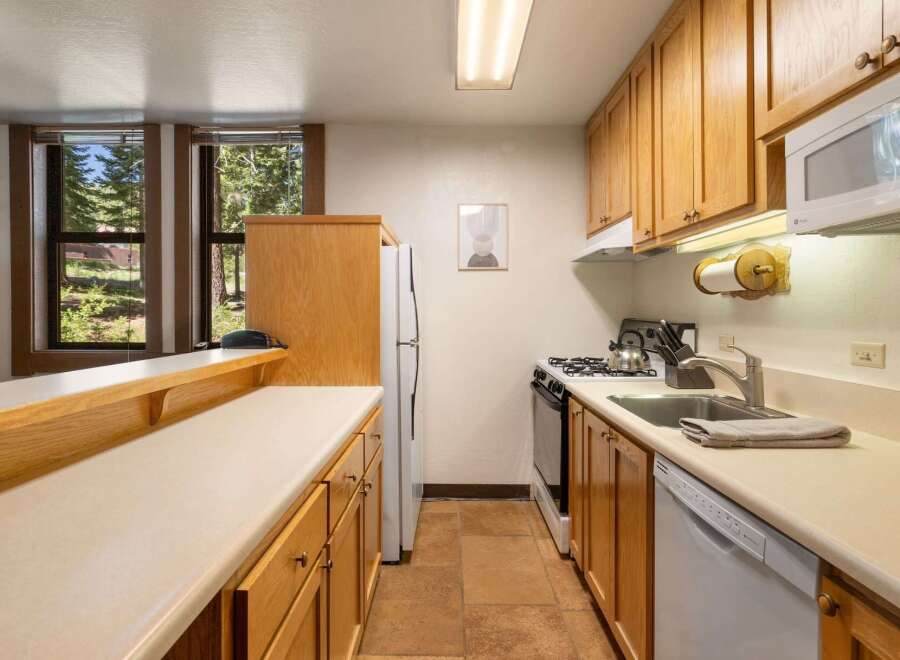 This charming kitchen features light wood cabinetry and a spacious countertop, perfect for meal preparation.
