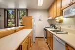 This charming kitchen features light wood cabinetry and a spacious countertop, perfect for meal preparation.