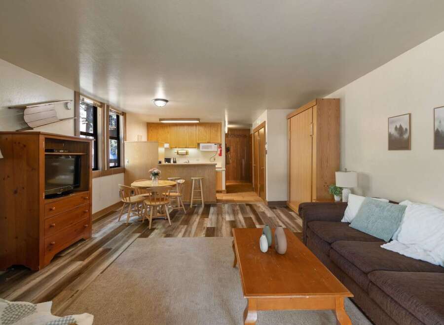 Discover this charming living space featuring a cozy living area with a comfortable sofa and coffee table, perfect for relaxation.