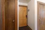 Step into this inviting entryway featuring a warm wooden door with a modern black lock, offering a secure and stylish welcome.