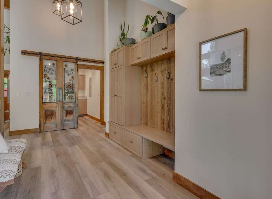Step into a charming entryway featuring rustic sliding barn doors that lead to a saloon-style bar area.