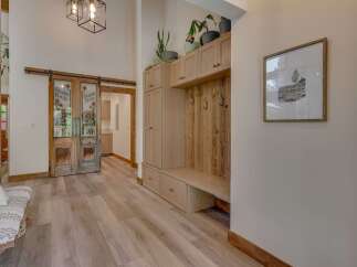 Step into a charming entryway featuring rustic sliding barn doors that lead to a saloon-style bar area.