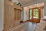 Step into this charming entryway featuring a custom built-in mudroom with ample storage and a cozy bench.