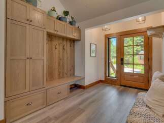 Step into this charming entryway featuring a custom built-in mudroom with ample storage and a cozy bench.