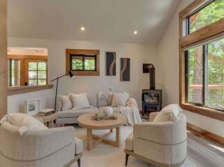 Experience cozy living in this inviting living room, featuring a modern wood-burning stove perfect for chilly evenings.