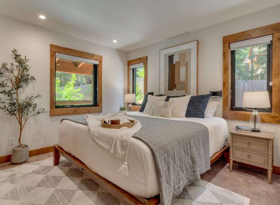 Experience serene living in this beautifully appointed bedroom, featuring a plush king-size bed adorned with decorative pillows and a cozy throw.