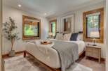 Experience serene living in this beautifully appointed bedroom, featuring a plush king-size bed adorned with decorative pillows and a cozy throw.