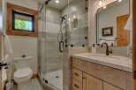 Experience luxury in this modern bathroom featuring a spacious glass-enclosed shower with elegant tile work and a sleek rainfall showerhead.