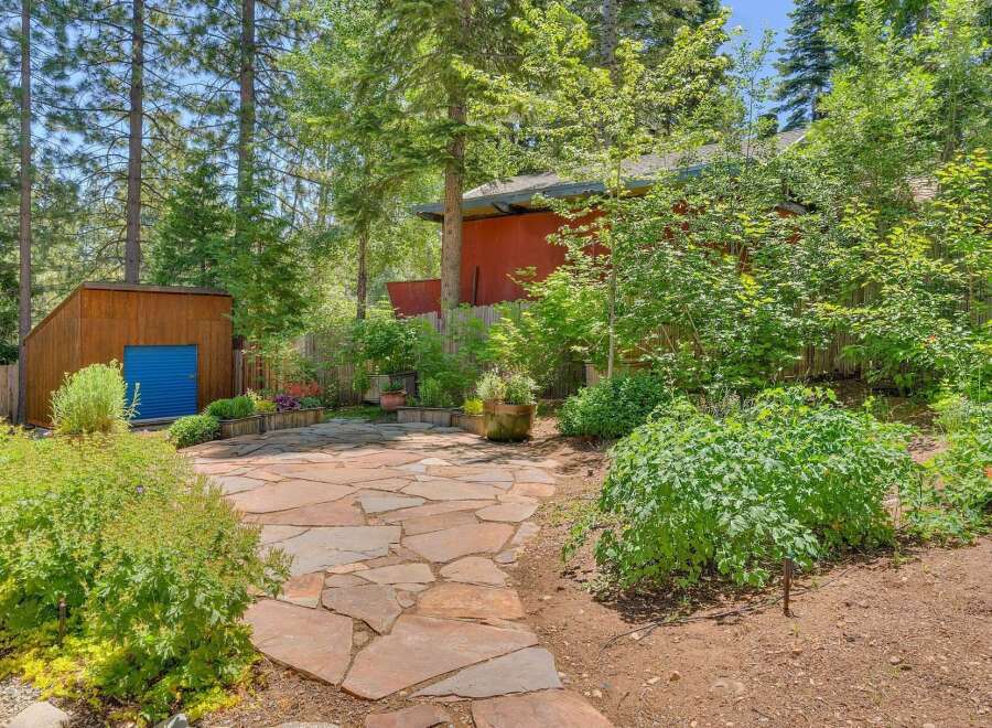 Discover this charming backyard oasis featuring a rustic flagstone patio perfect for outdoor entertaining.