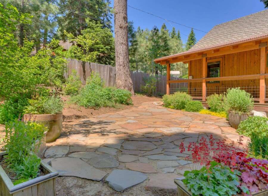 Discover this charming backyard oasis featuring a natural stone patio perfect for outdoor entertaining.