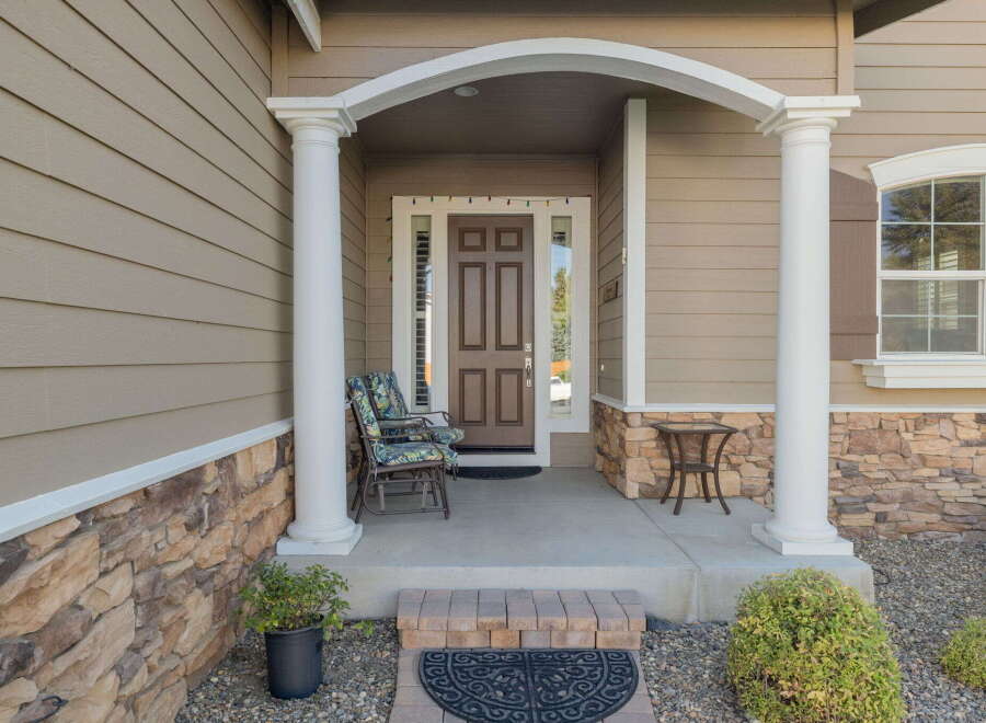 Welcome guests to this charming home with a covered front porch, perfect for enjoying your morning coffee.