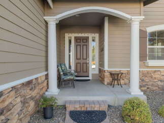 Welcome guests to this charming home with a covered front porch, perfect for enjoying your morning coffee.