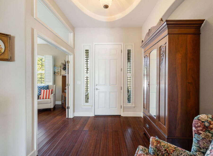 Step into this inviting entryway featuring a grand white door flanked by decorative sidelights.