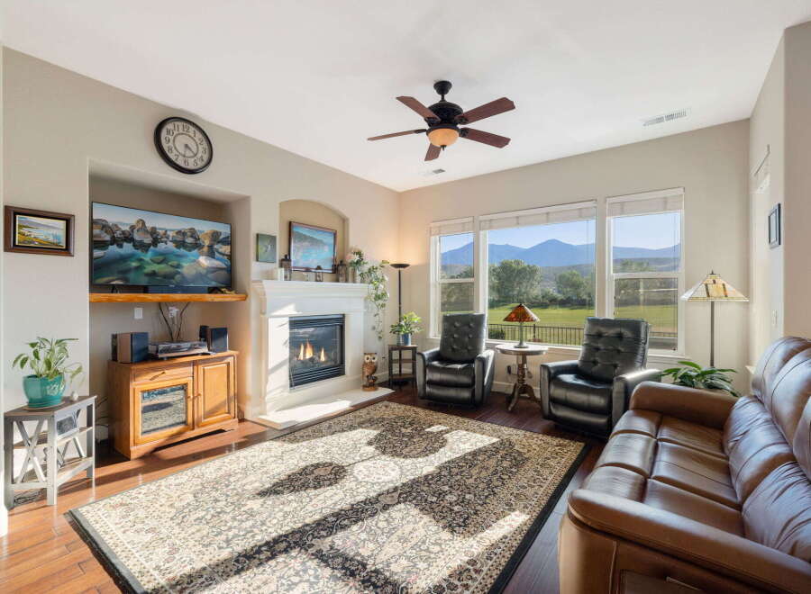 Experience breathtaking mountain views from this stunning living room, featuring a cozy fireplace and a large, ornate rug perfect for gathering.