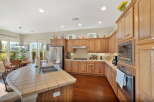 This spacious kitchen boasts beautiful oak cabinetry and a large tiled island with a double sink, perfect for meal preparation and entertaining.